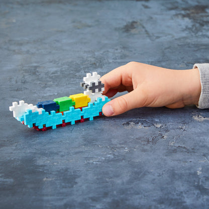 Hand playing with a Tube - Container Ship build on a gray surface