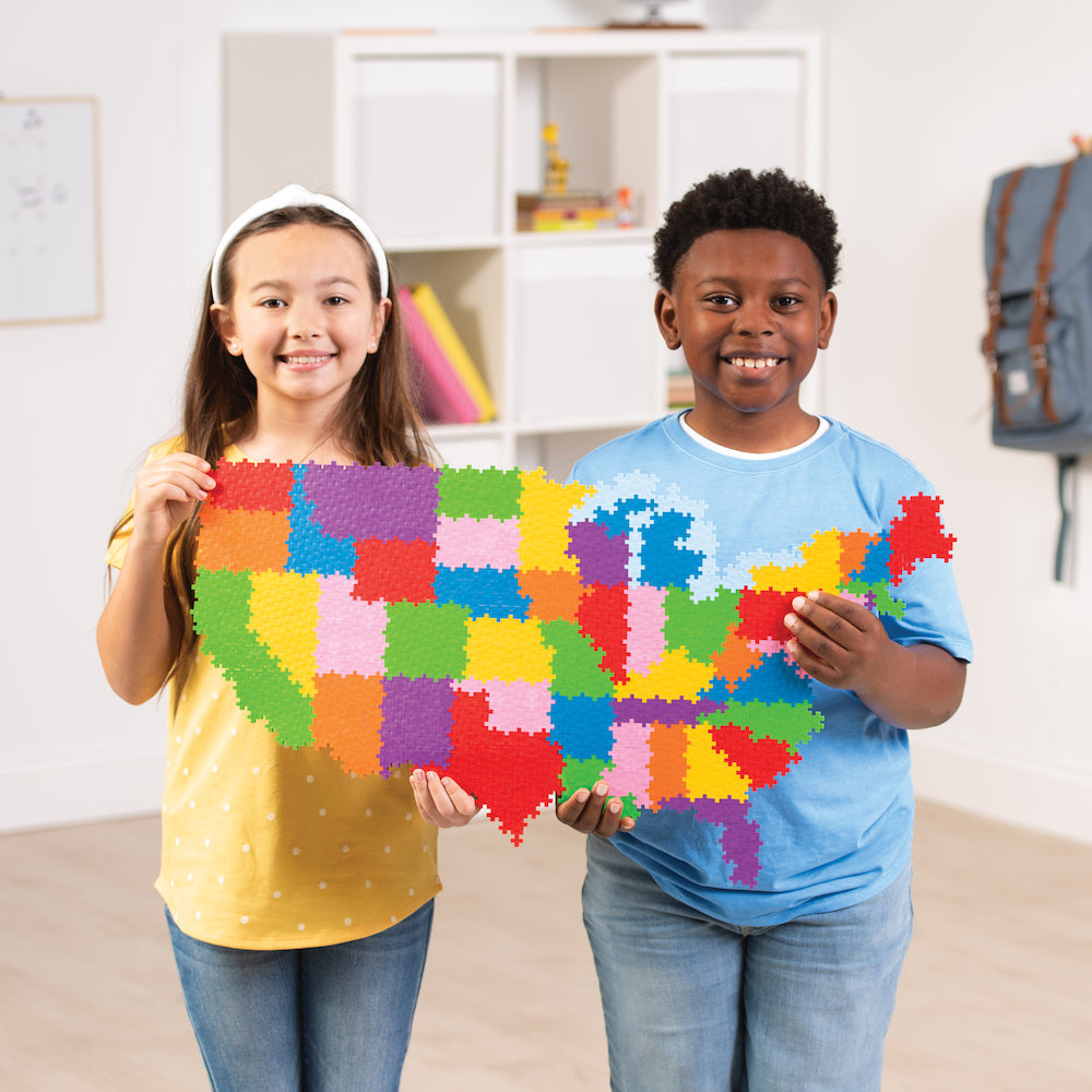 Two kids holding a completed Puzzle By Number® - 1400 pc Map of the United States