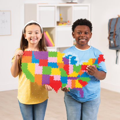 Two kids holding a completed Puzzle By Number® - 1400 pc Map of the United States